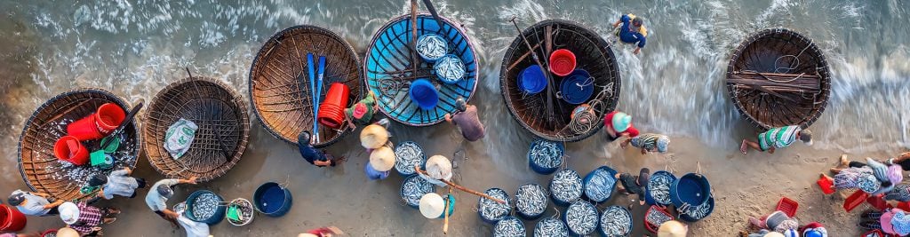 Asian fishing harbor or fishing village with people on the beach